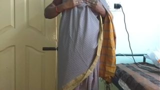Desi istri nakal dari India, Vanitha, mengenakan saree abu-abu ketat yang menampilkan payudara besar dan memamerkan vaginanya yang dicukur, meremas payudara dan menggosok klitorisnya dengan nafsu